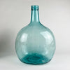 This vintage Spanish demijohn is made in hand blown blue green glass and bears the Viresa name embossed at the neck. Its broad rounded form and narrow collar identify it as a wine carboy bottle originally used for liquid storage, now ideal as a large decorative vase for olive branches in Mediterranean decor or rustic home decor.