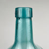 Large vintage Viresa bottle in hand blown blue green glass, made in Spain and shaped as a demijohn with broad rounded body and upright neck. The surface shows small age marks, internal bubbles, and slight optical distortion typical of handmade glass. It can be used as a floor bottle, bottle vase, or decorative vessel in coastal decor.