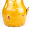 Antique earthenware jug from La Rioja with a rounded lower body, narrowed neck and wide mouth shaped into a clear pouring lip. The ochre glaze continues into the interior, where pronounced wheel-thrown rings remain visible, recording the handmade construction and giving this substantial Spanish pitcher a compelling folk pottery presence.