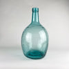 Large Viresa demijohn in blue glass from Spain, made in hand blown utility glass with a substantial rounded body, tapered neck, and visible irregular bubbles suspended in the glass. This vintage bottle works as a sculptural floor vase, statement table centerpiece, or oversized bottle decor in coastal decor and vintage home decor settings.