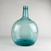 Large Viresa demijohn in blue glass from Spain, made in hand blown utility glass with a substantial rounded body, tapered neck, and visible irregular bubbles suspended in the glass. This vintage bottle works as a sculptural floor vase, statement table centerpiece, or oversized bottle decor in coastal decor and vintage home decor settings.