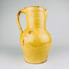 Antique Spanish terracotta jug in yellow glazed earthenware, sourced in Burgos, Castile, northern Spain. This 19th century pottery pitcher has a rounded body, straight neck, single strap handle, and pinched spout. The worn glaze and exposed clay suit Mediterranean decor, farmhouse decor, and rustic home decor.