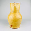 Spanish folk pottery jug in yellow glazed terracotta with a bulbous lower body and tall neck, dating to the 19th century. The handmade earthenware surface shows craquelure, firing variation, and age wear across the glaze. This antique Spanish pitcher works as a decorative vessel for Mediterranean decor and wabi sabi decor.