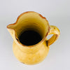 Detail highlighting the rim wear and interior of this antique Spanish terracotta jug, where chips, glaze losses, and age marks show the red clay body beneath the yellow finish. These visible imperfections support its old farmhouse pottery character and make it especially suitable for collectors of authentic Spanish earthenware and rustic decor.