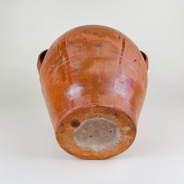 Rustic terracotta floor vase made from Spanish earthenware clay, with a heavy 8.2 kg body, rounded shoulders, two loop handles, and warm glaze movement over the orange surface. The piece fits Mediterranean decor, farmhouse decor, wabi sabi decor, and natural interiors where antique pottery adds texture and scale.