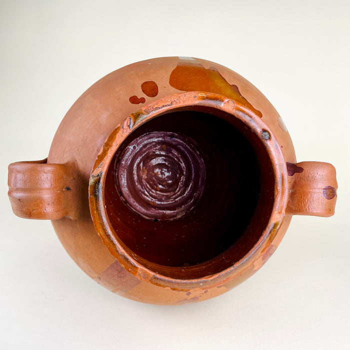 Antique terracotta floor vase in red-orange Spanish earthenware, featuring a rounded storage jar shape, wide neck, raised loop handles, and glossy glaze trails descending from the rim and shoulder. The vessel adds texture to Mediterranean decor, rustic home decor, wabi sabi decor, and organic modern rooms.