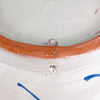 A ceramic vessel with a white glazed interior and exterior featuring a terracotta-coloured rim. The exterior surface displays hand-painted blue linear accents and small circular perforations near the top edge of the clay body.