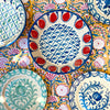 Hand painted Granada Fajalauza lebrillo bowl with a blue rim, red pomegranate border, and central blue lattice pattern on a cream glazed terracotta body. This contemporary Spanish pottery piece can be used as a decorative bowl, sculptural table centerpiece, or wall hanging ceramic in farmhouse decor and rustic home decor settings.