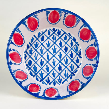 Large Spanish Fajalauza lebrillo bowl made in Granada, Spain, hand painted in red and blue over a cream-white glazed terracotta body. The deep rounded form, red pomegranate border, blue rim, and geometric central lattice make it suitable as a table centerpiece, fruit bowl, or Mediterranean decor wall display.