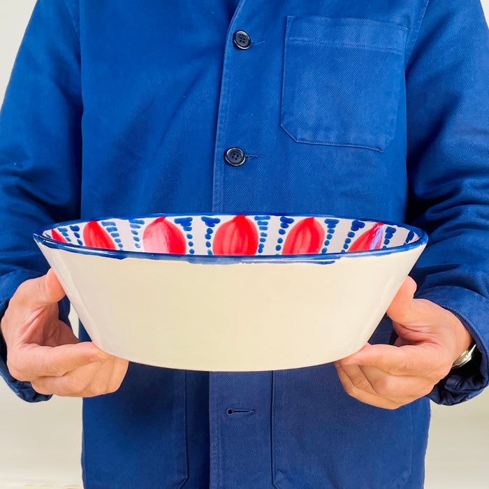 Contemporary hand painted Granada Fajalauza bowl with red pomegranate motifs around the interior wall and blue geometric decoration across the central basin. The hand thrown terracotta form gives this Spanish ceramic bowl weight and depth, making it useful as decorative pottery for farmhouse decor, cottage decor, or rustic home decor.
