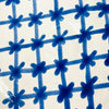 Thick cobalt blue rim and patterned interior of a large Spanish lebrillo bowl, with hand painted wavy bands and tapering botanical forms over a creamy white glaze. The deep Granada pottery form is suitable as a substantial serving bowl for fruit or salad and also includes pierced hanging holes for use as decorative ceramic wall art.