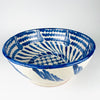 Hand painted Spanish lebrillo bowl in the Fajalauza tradition, showing the contrast between its simple cobalt exterior motifs and richly decorated interior. The deep glazed terracotta vessel has an irregular handmade profile, visible brush variation and a strong blue and white palette suited to Mediterranean decor, rustic home decor and ceramic collecting.