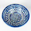 Large blue and white Granada lebrillo bowl with a spiral interior composition of cobalt leaf forms, wavy border bands and a central floral lattice. The traditional terracotta serving bowl has a substantial depth and footed base, while pierced holes near the rim allow it to function as a ceramic wall hanging or decorative wall plate.