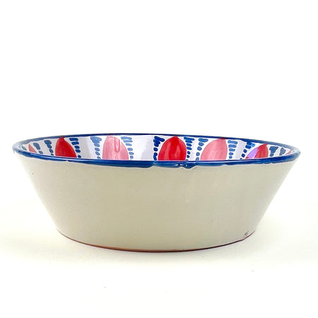 Contemporary hand painted Granada Fajalauza bowl with red pomegranate motifs around the interior wall and blue geometric decoration across the central basin. The hand thrown terracotta form gives this Spanish ceramic bowl weight and depth, making it useful as decorative pottery for farmhouse decor, cottage decor, or rustic home decor.