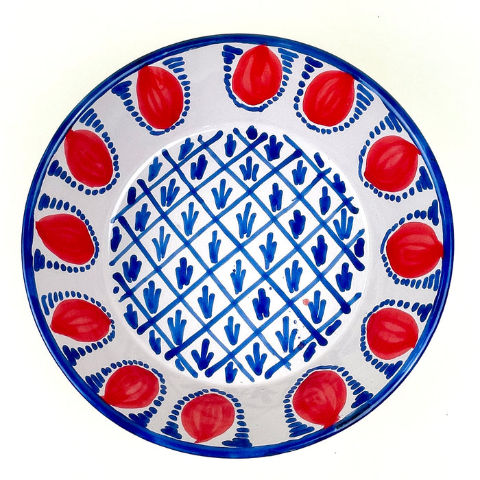 Hand thrown Spanish ceramic lebrillo bowl with a thick terracotta body, glazed cream interior, blue rim, and repeated red pomegranate decoration. The form follows the Andalusian lebrillo tradition while the original ROC design gives it contemporary appeal for coastal decor, farmhouse decor, and layered ceramic displays.
