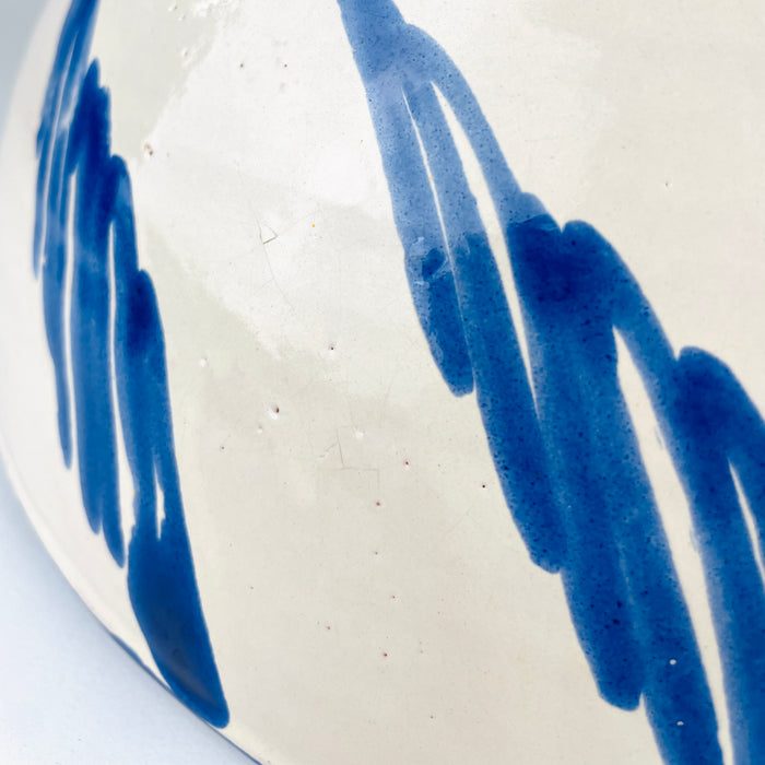Blue and white Spanish pottery bowl with a deep footed form and an all-over hand painted interior, produced by Cerámica Los Arrayanes in Granada. Cobalt brushstrokes form a central flowered grid surrounded by rotating botanical motifs, giving this substantial lebrillo visual movement and a strong decorative presence on a table or wall.