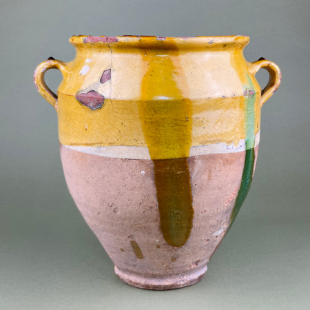 Side angle showing the antique confit pot’s glaze detail and handle structure. The vibrant ochre glaze transitions into rustic terracotta base, highlighting hand-thrown form and organic irregularities typical of rural 19th-century French pottery from Southwest regions.