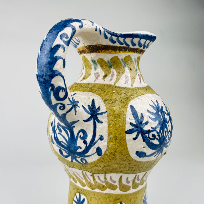 Oblique angle showing the bulbous midsection and flared neck of this Vintage French Quimper vase. The blue and ochre palette captures avantgarde modernism, ideal for styling in mid century decor, farmhouse tables, or rustic home collections.