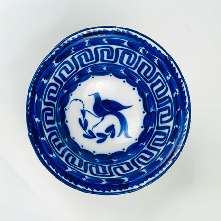 Spanish Manises blue white ceramic bowl in tin glazed earthenware, decorated with a central cobalt bird and leafy stem, framed by dotted accents and a Greek key meander border. This traditional Valencia ceramics look pairs with Mediterranean decor, French country decor, and japandi decor where one historic blue white piece adds contrast to neutral interiors.