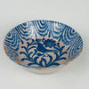 Antique Granada Fajalauza bowl made from tin glazed earthenware, decorated in cobalt blue with a bird and floral motif. The interior rim shows repeating wave bands and drip marks that create a bold border against the ivory glaze. Suitable for Spanish tableware, serving olives, citrus, or salads, and for Mediterranean decor shelves with collected ceramics.