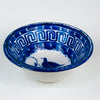 Antique Spanish Manises ceramic deep bowl in blue and white tin glazed earthenware from the Valencia region, featuring a hand painted cobalt bird in the center with a curling leafy branch. The rim is structured with a Greek key border and bold cobalt brushwork, ideal for Mediterranean decor styling and blue white kitchen decor.