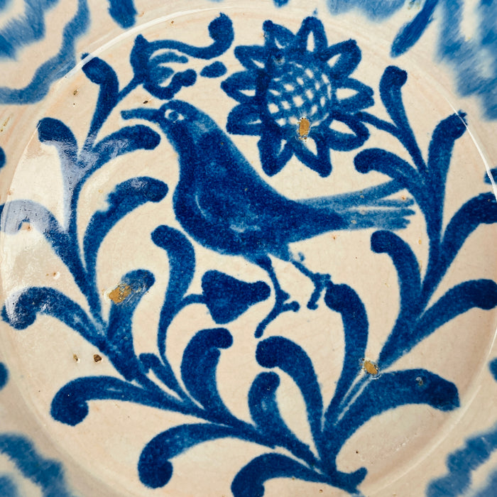 Vintage Granada Fajalauza serving bowl, tin glazed earthenware, hand painted in cobalt blue with a bird, rosette flower, and foliate scroll motif. The wide rim area is patterned with layered wave lines that echo traditional Andalusian brushwork. Works as salad bowl, tapas serving bowl, or decorative bowl centerpiece for farmhouse decor tables and Spanish pottery collectors.