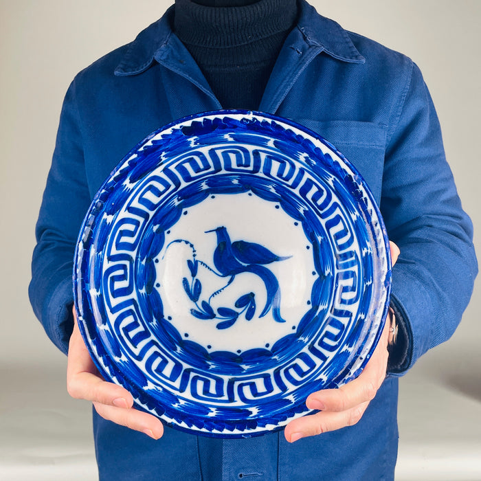 Vintage Blue and white Spanish Manises bowl from Valencia, tin glazed ceramic with hand painted cobalt bird motif and scrolling leaf branch. The border uses a classic Greek key pattern and rhythmic cobalt brush marks that read clearly on a tabletop, suitable as a decorative bowl, fruit bowl, or serving bowl for Mediterranean decor and vintage home decor.