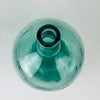 Handblown style glass demijohn vase in blue aqua Spanish glass, originally used as a wine carboy or damajuana. The raised V. Ayelense neck mark, rounded body, thick rim, visible bubbles, and handmade character make it suitable for display with tall stems or as an empty sculptural bottle in Mediterranean decor.