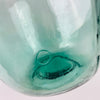 Spanish blue glass demijohn with V. Ayelense neck mark, identifying the maker on the raised collar of the bottle. The piece has a rounded wine carboy body, narrow neck, aqua blue green glass, and visible bubbles, making it a distinctive decorative vase for collectors of vintage glass and Mediterranean home decor.