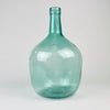 V. Ayelense glass demijohn from Spain, made in blue green aqua glass with a round body, thick neck rim, visible bubbles, and raised lettering identifying the maker. The piece functions today as a demijohn vase, wine carboy display bottle, or sculptural glass accent for farmhouse decor, coastal decor, and vintage kitchen styling.