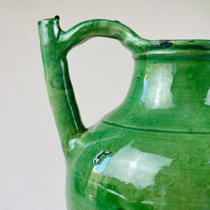 Close-up of the green glaze texture on the gargolette neck and shoulder, showing crackle and brush marks
Detail of the antique French gargolette’s emerald green glaze reveals surface irregularities, brush strokes, and crackling, emphasizing the handcrafted nature of this rustic 19th-century pottery water jug used in traditional rural households.