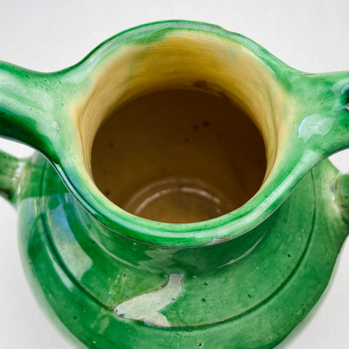 Top-down view inside the jug, showing depth, inner glaze, and circular form of the vessel opening
Photographed from above, the jug’s circular opening and inner ochre glaze are visible, showcasing the utilitarian design and craftsmanship of antique French water jugs—now often styled as rustic kitchen accents or sculptural Mediterranean centerpieces.