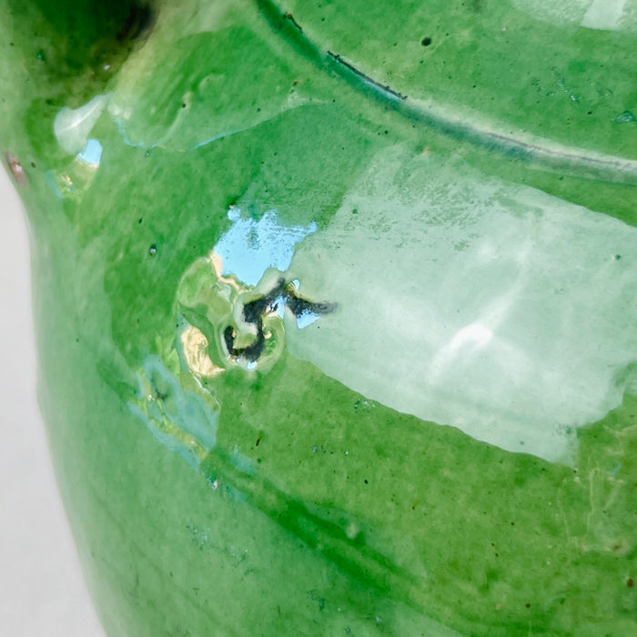 Mid-range image capturing the full height and width of the jug in a well-lit interior setting
This straight-on image showcases the proportions and color depth of the antique green-glazed gargolette, positioned as a standalone statement piece perfect for shelf styling, entryway table displays, or rustic kitchen vignettes.