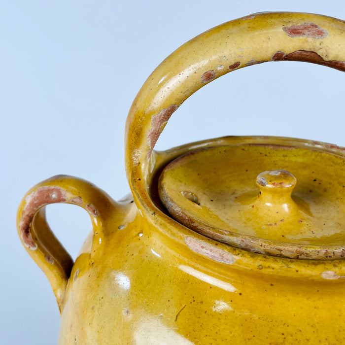 Large antique terracotta vase from France, originally made as a yellow glazed water jug or gargoulette. The vessel has a rounded body, arched top handle, side spout, removable lid, and worn pale clay base, combining practical 19th century rural pottery form with decorative appeal for French country decor and antique and vintage interiors.