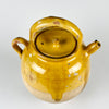 Antique French terracotta water jug with yellow glazed upper body, removable lid, side spout, arched handle, and side loop handle. This large gargoulette pot has the form of a rural 19th century water vessel, with visible glaze losses, exposed clay, firing marks, and surface wear that support use as antique pottery decor or a sculptural vase.