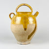 Large antique French yellow gargoulette pot in glazed terracotta, made as a 19th century water jug with an arched carrying handle, side spout, side loop handle, and removable lid. The upper section has honey yellow glaze, while the lower body shows pale unglazed terracotta with patina, making it suitable for French country decor and rustic home decor.