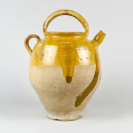 Large antique French yellow gargoulette pot in glazed terracotta, made as a 19th century water jug with an arched carrying handle, side spout, side loop handle, and removable lid. The upper section has honey yellow glaze, while the lower body shows pale unglazed terracotta with patina, making it suitable for French country decor and rustic home decor.