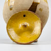 French folk pottery gargoulette jug in yellow glazed terracotta, with a removable lid, side pouring spout, side handle, and large arched handle. The unglazed lower body shows clay texture, tool marks, mineral inclusions, and staining, while the glazed upper surface has chips and patina from age and use, ideal for rustic home decor.
