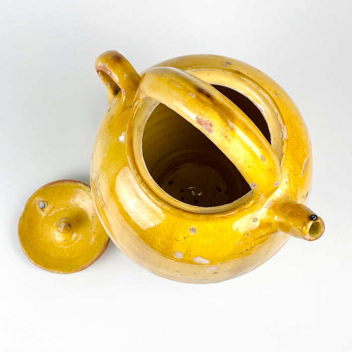 Mediterranean decor object made from French yellow terracotta, originally a gargoulette water jug with lid and spout. The large rounded shape, arched handle, honey glaze, unglazed lower body, and visible patina create a sculptural antique pottery vessel for a kitchen, console, shelf, or rustic interior display.