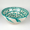 Fajalauza lebrillo bowl in green and cream glazed terracotta, with a deep rounded form, thick painted rim, and traditional bird and foliate decoration. The Spanish ceramic wall hanging hole on the reverse supports display as wall art, while the large bowl shape also works as a centerpiece in Mediterranean decor.