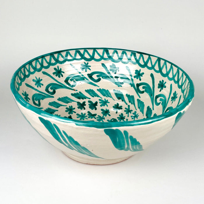 Fajalauza lebrillo bowl in green and cream glazed terracotta, with a deep rounded form, thick painted rim, and traditional bird and foliate decoration. The Spanish ceramic wall hanging hole on the reverse supports display as wall art, while the large bowl shape also works as a centerpiece in Mediterranean decor.