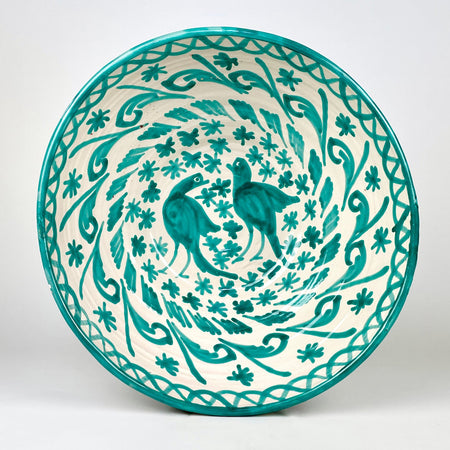Large Spanish Fajalauza lebrillo bowl in hand painted green terracotta, with a cream white glazed ground, twin bird motif, scrolling foliage, floral decoration, and a green rim. The deep rounded form and pierced reverse hole make it suitable as a decorative bowl, ceramic wall hanging, or Mediterranean decor object.