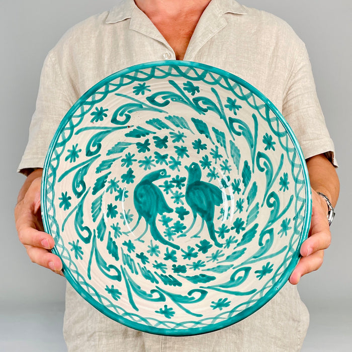 Large Granada ceramic bowl in the Fajalauza tradition, decorated in green over a cream glazed surface with two birds, floral details, leafy scrolls, and a painted rim. The terracotta bowl has a strong wall hanging presence and works well as Mediterranean decor, rustic home decor, or a collected Spanish ceramic object.