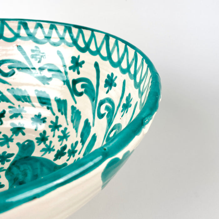 Green hand painted Fajalauza bowl with twin bird decoration, foliate scrolls, floral patterning, and a bold turquoise green border. This Spanish lebrillo bowl is made from glazed terracotta and can be used as ceramic wall art, a decorative serving bowl, or a statement pottery piece for farmhouse decor and rustic home decor.