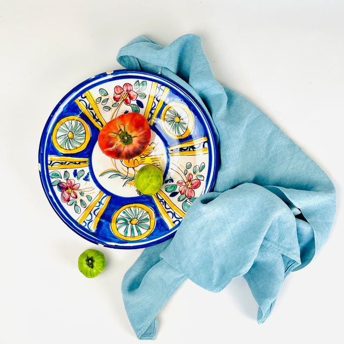 Antique large Manises bird charger in tin glazed earthenware, hand painted around circa 1900 with a golden yellow bird, cobalt blue radial border, pink flowers, green foliage and geometric rosettes. This Spanish majolica wall plate combines folk pottery character with the scale and color needed for a Mediterranean decor centerpiece.