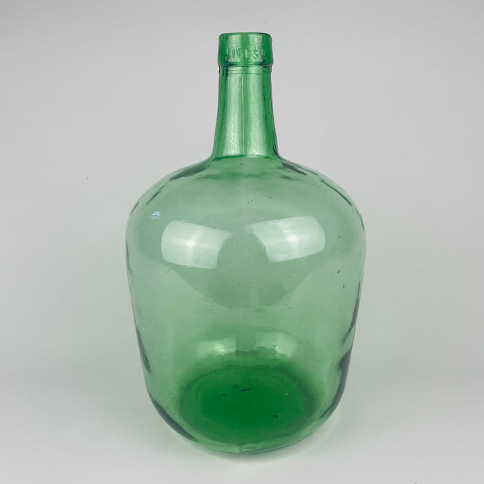 Vintage Spanish bottle vase formed as a 5 L green glass demijohn by VIRESA in Benigànim, Valencia, circa 1960s. Transparent sea green color, darker emerald accents, a broad body and narrow neck make it practical for long dried stems, eucalyptus or olive branches. The utilitarian wine carboy form complements Mediterranean decor without appearing overly rustic.