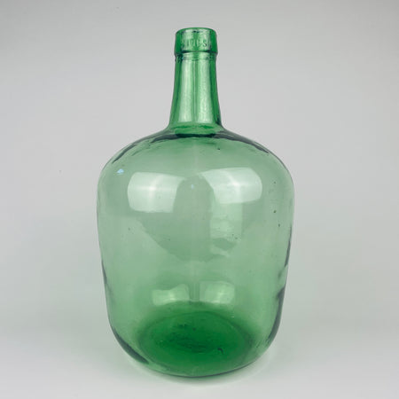 Vintage Spanish green glass demijohn vase made by VIRESA in Benigànim, Valencia, circa 1960s, held at torso height to show its medium 32 cm scale. The 5 L wine carboy has a broad rounded body, narrow neck, reinforced rim, luminous sea green color and natural bubbles, making it a distinctive vessel for Mediterranean decor.