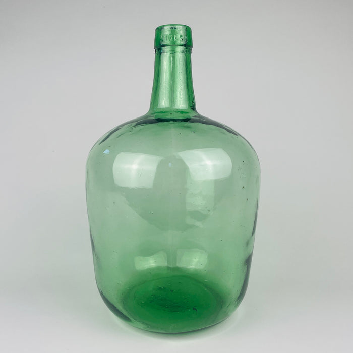 Vintage Spanish green glass demijohn vase made by VIRESA in Benigànim, Valencia, circa 1960s, held at torso height to show its medium 32 cm scale. The 5 L wine carboy has a broad rounded body, narrow neck, reinforced rim, luminous sea green color and natural bubbles, making it a distinctive vessel for Mediterranean decor.
