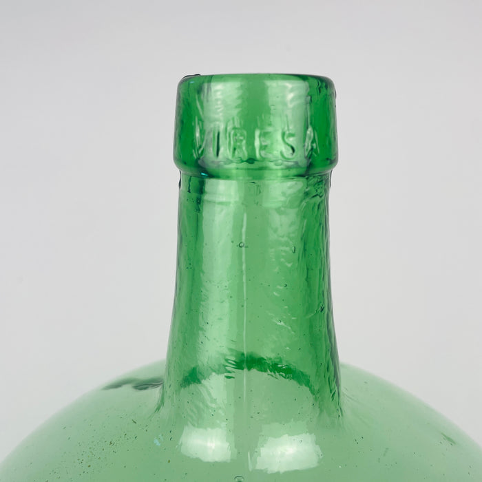 vintage VIRESA green glass demijohn made in Benigànim, Valencia, circa 1960s, showing the vertical mould seam along the tapered neck and the reinforced bottle mouth. Natural bubbles and subtle glass waves remain visible around the 5 L mark, confirming the character of mid century Spanish utilitarian glass rather than modern decorative glassware.