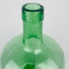 Embossed VIRESA maker name on the reinforced neck of a vintage Spanish green glass demijohn from Benigànim, Valencia, circa 1960s. The mould blown construction produces a visible seam, gentle waviness and trapped air bubbles that document its industrial manufacture. This marked 5 L wine carboy now works as authentic Spanish vintage decor.